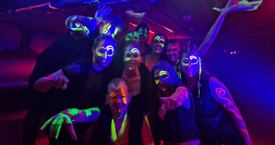 Leden van Fenix Drums met neon-schmink onder blacklight