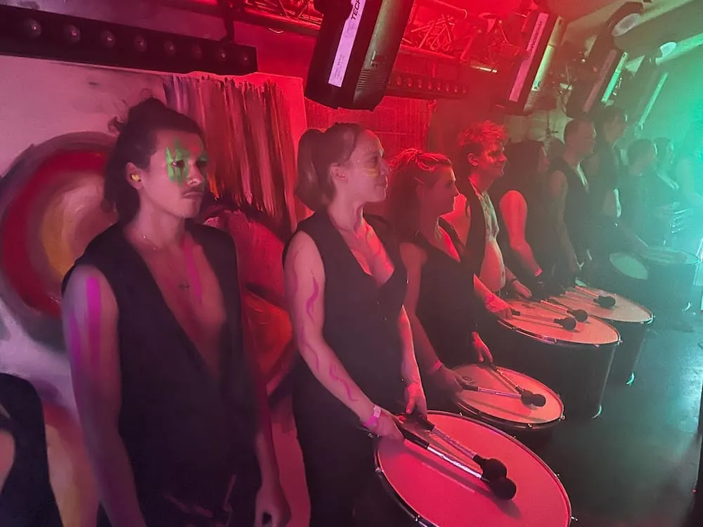 Drummers in een rij tijdens een optreden in een club met rood licht